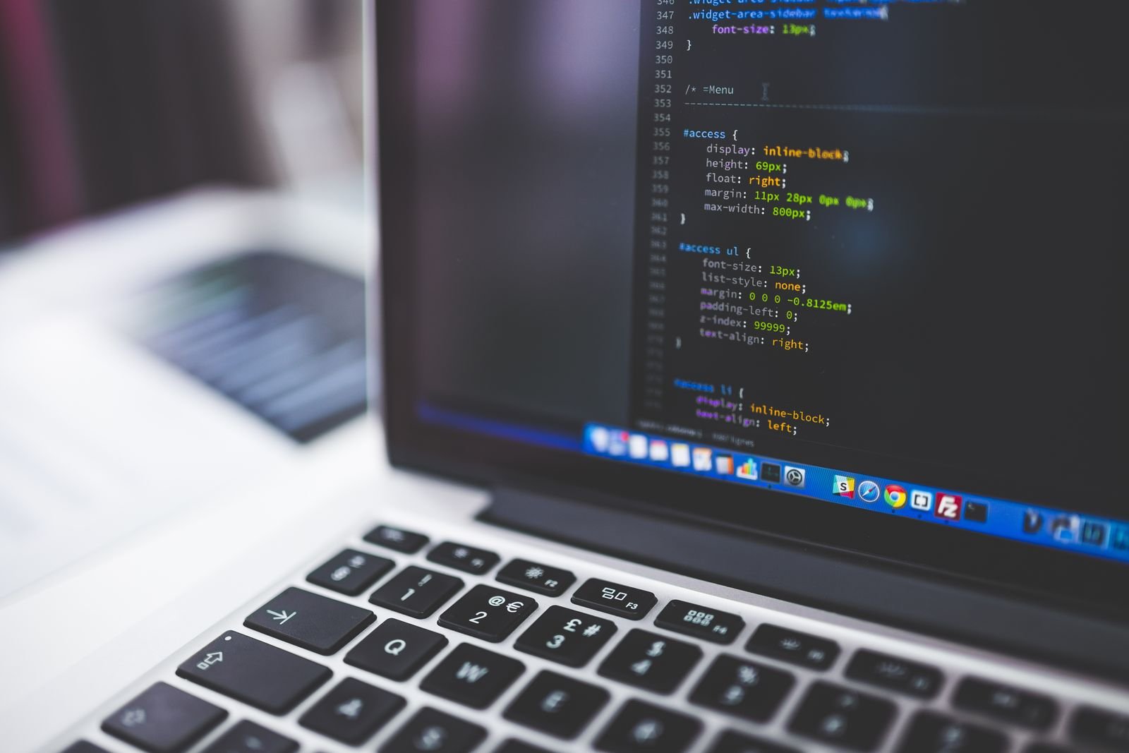 Website code displayed on a professional laptop